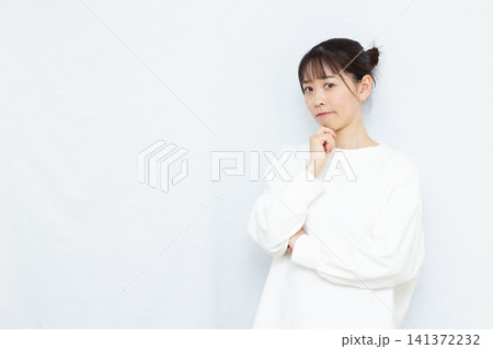 腕組みをして悩んでいる女性 腕組みをして悩んでいる女性 141372232