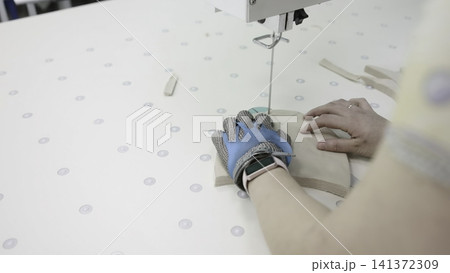 Fabric Guiding On Perforated Work Surface. Steady Stitching Performed By Skilled Machine Operators . Media Fabric Guiding On Perforated Work Surface. Steady Stitching Performed By Skilled Machine Operators . Media 141372309