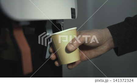 Coffee Break Moment. Employee Refills Disposable Cup With Hot Coffee In Morning Office Environment. Media Coffee Break Moment. Employee Refills Disposable Cup With Hot Coffee In Morning Office Environment. Media 141372324