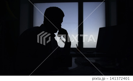 Figure In Dimly Lit Office Communicates Covertly With Someone About Highstakes Case Details . Media Figure In Dimly Lit Office Communicates Covertly With Someone About Highstakes Case Details . Media 141372401