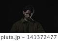 Solitary young man in dramatic low key lighting 141372477