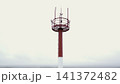 Red and white tower mast against a cloudy sky 141372482