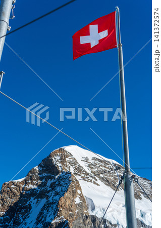 スフィンクス展望台の国旗とユングフラウ山頂。ユングフラウヨッホ、ベルン州、スイス 141372574
