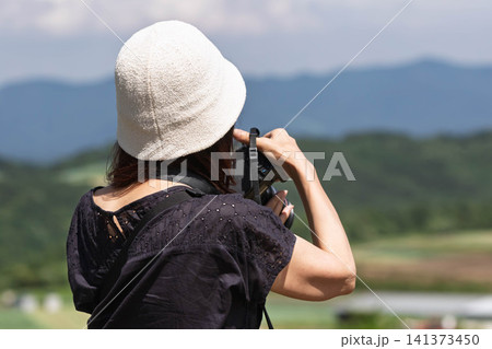 愛妻の丘からの風景を撮影する女性　群馬県嬬恋村 141373450