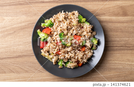 Lentil fried rice with broccoli and bell peppers on wooden background, Vegetarian food 141374621