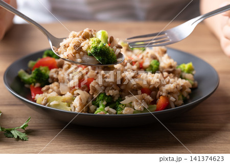 Lentil fried rice with broccoli and bell peppers on black plate ready to eat Lentil fried rice with broccoli and bell peppers on black plate ready to eat 141374623