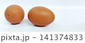 Two fresh brown chicken eggs against a white background. 141374833