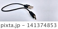 A short, black micro-USB to USB Type-A charging cable on a white surface. 141374853