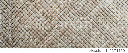Close-up photo of the texture of a handmade woven straw mat. 141375330