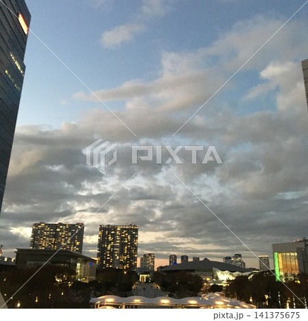 夕暮れの都会に灯るビルの明かりと広がる雲の風景 夕暮れの都会に灯るビルの明かりと広がる雲の風景 141375675