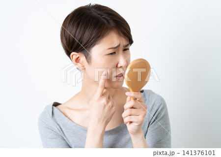 顔のにきびに悩む女性 141376101