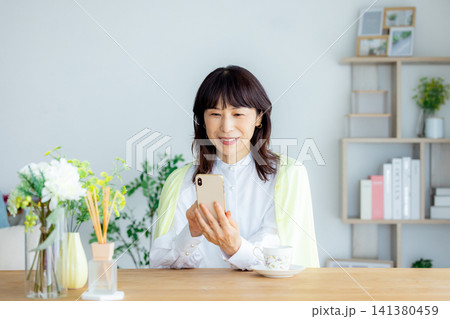 スマホを見るミドルシニア女性 スマホを見るミドルシニア女性 141380459