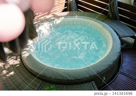 Inflatable hot tub with bubbling water on outdoor terrace Inflatable hot tub with bubbling water on outdoor terrace 141381696