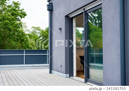 Open sliding glass door leads from rooftop terrace into modern apartment. Open sliding glass door leads from rooftop terrace into modern apartment. 141381703