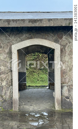 Weathered stone doorway framing a lush garden view Weathered stone doorway framing a lush garden view 141383001