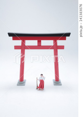 Miniature Shinto priest and maiden by torii gate. Miniature Shinto priest and maiden by torii gate. 141383076