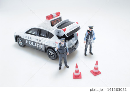Miniature Japanese police officers stand by patrol car. Miniature Japanese police officers stand by patrol car. 141383081