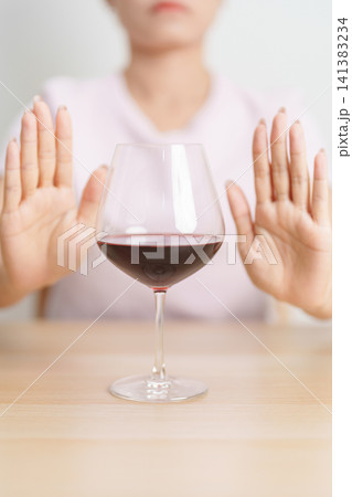 woman making stop hand gesture to refuse a glass of Wine, Healthy man say no to alcohol drink, stop alcoholism and addiction concept. Responsible man reject a drink before driving and quit booze woman making stop hand gesture to refuse a glass of Wine, Healthy man say no to alcohol drink, stop alcoholism and addiction concept. Responsible man reject a drink before driving and quit booze 141383234