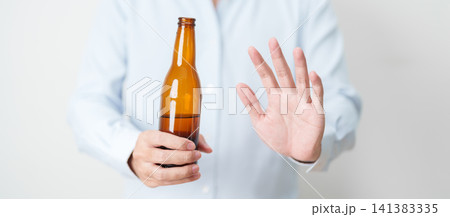 man making stop hand gesture to refuse a bottle of Beer, Healthy man say no to alcohol drink, stop alcoholism and addiction concept. Responsible man reject a drink before driving and quit booze 141383335