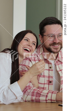 Vertical video Young family signing agreement with housing agent buying apartment getting keys. Couple moving to new apartment. Real estate concept. 141385222