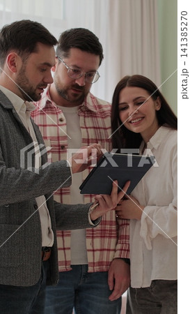 Vertical video Young family choosing new house or apartment, meeting with real estate agent, trying to take decision and make right choice of accommodation. 141385270