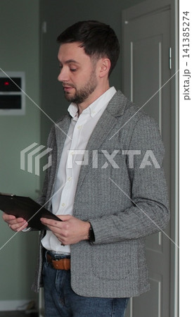 Vertical video Young couple with real-estate agent visiting apartment for sale or for rent. Loving people buying an apartment. Real estate concept. 141385274