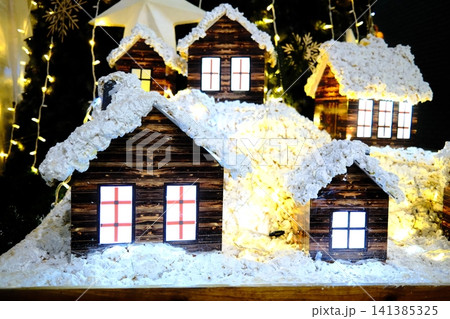 Miniature winter houses covered in snow at night Miniature winter houses covered in snow at night 141385325