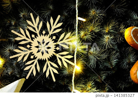 Golden snowflake ornament on dark Christmas tree Golden snowflake ornament on dark Christmas tree 141385327