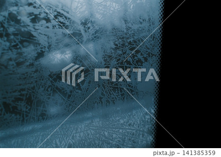 Intricate winter frost covers an automobile windshield Intricate winter frost covers an automobile windshield 141385359