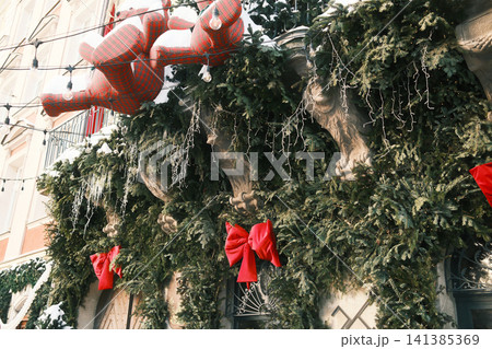 Winter holiday display with large plaid bear and green garlands 141385369