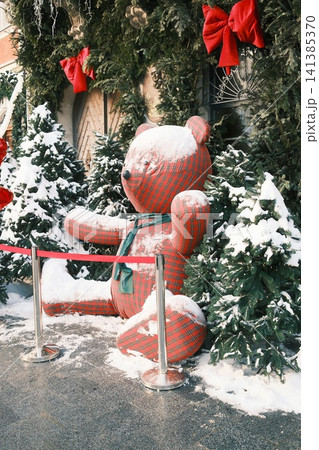 Outdoor winter display with snowy plaid teddy bear Outdoor winter display with snowy plaid teddy bear 141385370