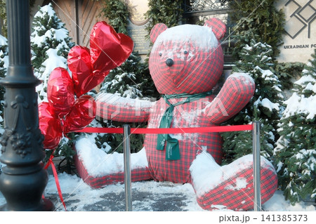 Snow covered teddy bear with red heart balloons Snow covered teddy bear with red heart balloons 141385373
