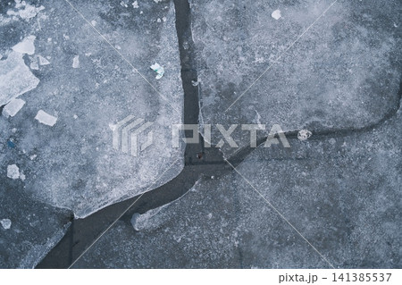 Broken ice with jagged chunks floats on dark winter water, showcasing patterns Broken ice with jagged chunks floats on dark winter water, showcasing patterns 141385537