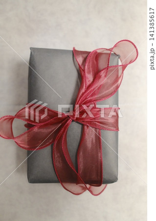 Gray wrapped gift with vibrant red bow Gray wrapped gift with vibrant red bow 141385617
