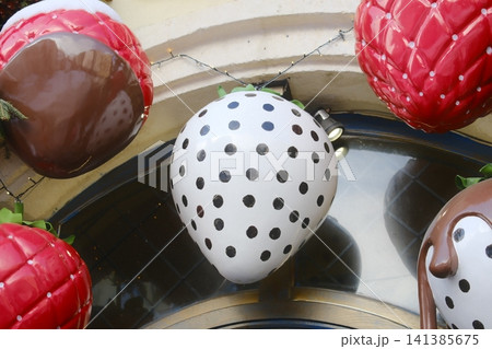 Close-up of giant decorative artificial strawberry props on building facade Close-up of giant decorative artificial strawberry props on building facade 141385675