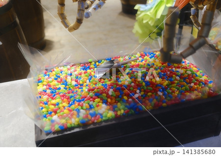 A large bin full of red, blue, green, yellow, and white jelly beans 141385680