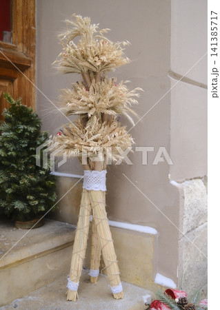 Didukh (wheat, lace) on snowy steps by a potted Christmas tree Didukh (wheat, lace) on snowy steps by a potted Christmas tree 141385717