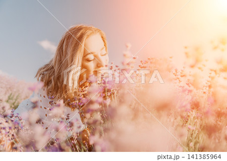 Lavender woman field smelling blooming purple flowers in a sunny meadow at golden hour for summer relaxation and aromatherapy Lavender woman field smelling blooming purple flowers in a sunny meadow at golden hour for summer relaxation and aromatherapy 141385964