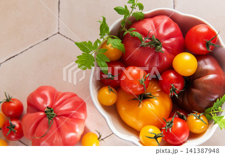 Fresh organic heirloom tomatoes in white bowl Fresh organic heirloom tomatoes in white bowl 141387948