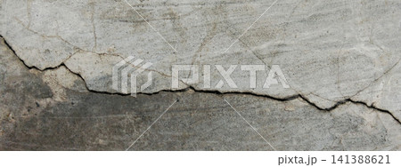 Concrete surface with deep cracks and a layered plaster texture. 141388621