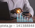 Young man with computer notebook and smartphone hand touching to visualize money growth  141388848