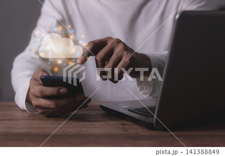 Young man with computer notebook and smartphone mobile hand touching to cloud computing diagram Young man with computer notebook and smartphone mobile hand touching to cloud computing diagram 141388849