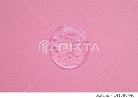 Close-up of clear serum droplet with bubbles on pink background for skincare and cosmetic concept 141390446