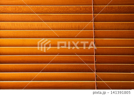Minimalist closeup of wooden venetian blinds with warm tones and visible slats, capturing natural materials and a peaceful indoor atmosphere. Minimalist closeup of wooden venetian blinds with warm tones and visible slats, capturing natural materials and a peaceful indoor atmosphere. 141391805