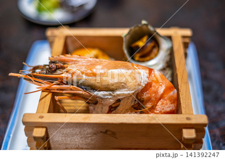 【#旅館料理】木箱に盛られた大海老とサザエの豪華な海鮮料理 141392247