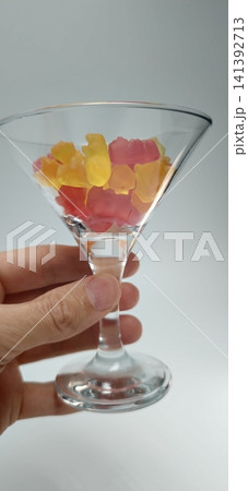 Gummy candies in a glass cup held by a person's hand at home Gummy candies in a glass cup held by a person's hand at home 141392713