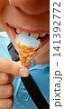 Child enjoys ice cream cone on a sunny day outdoors in the park 141392772