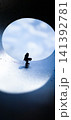 Small figure stands inside a circular opening looking towards the sky 141392781