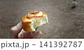 Freshly baked roll is held in hand with a bite taken from it 141392787