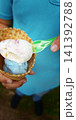 Enjoying ice cream in a cone on a sunny day at a local park 141392788